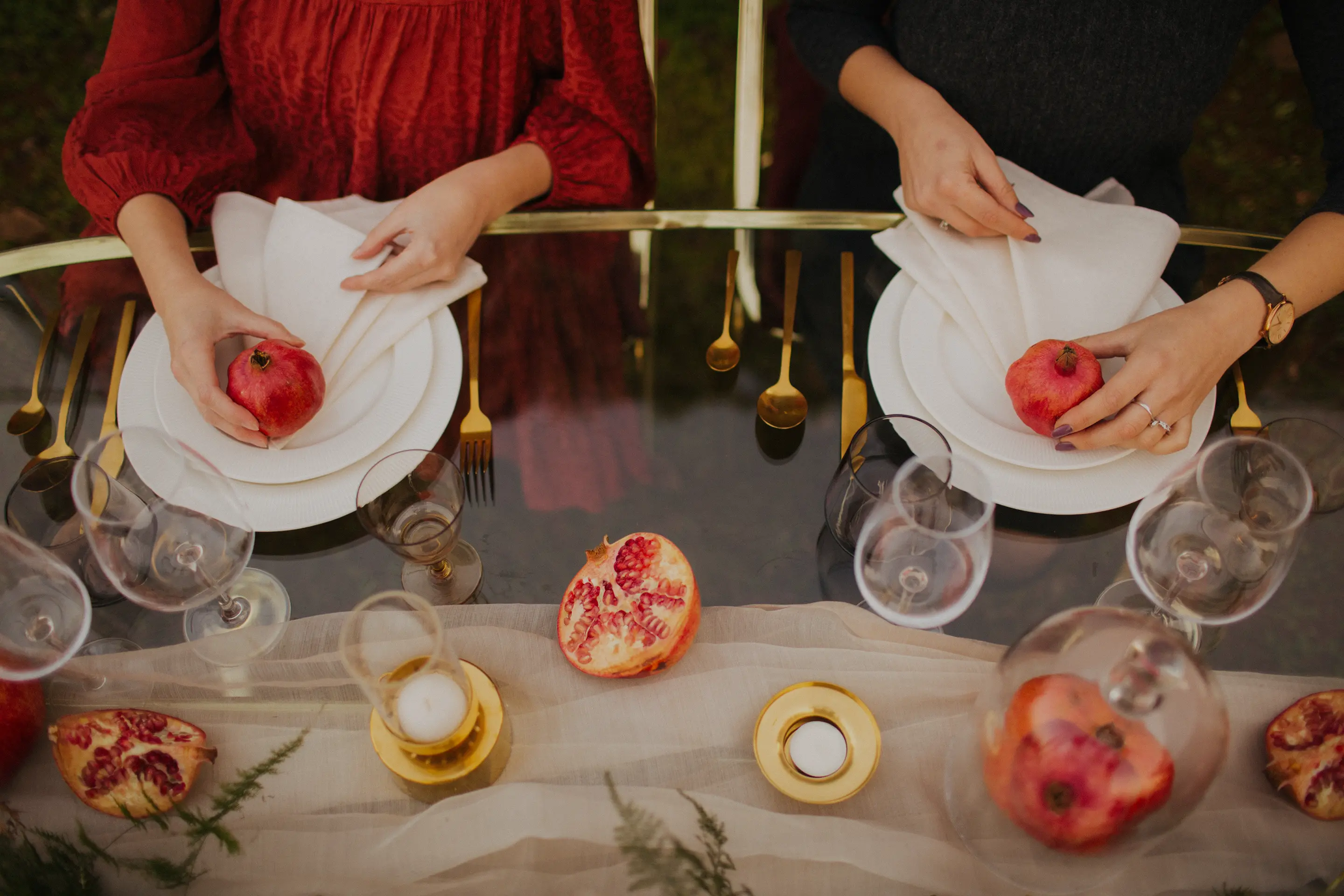 two women hands holding pomegranate