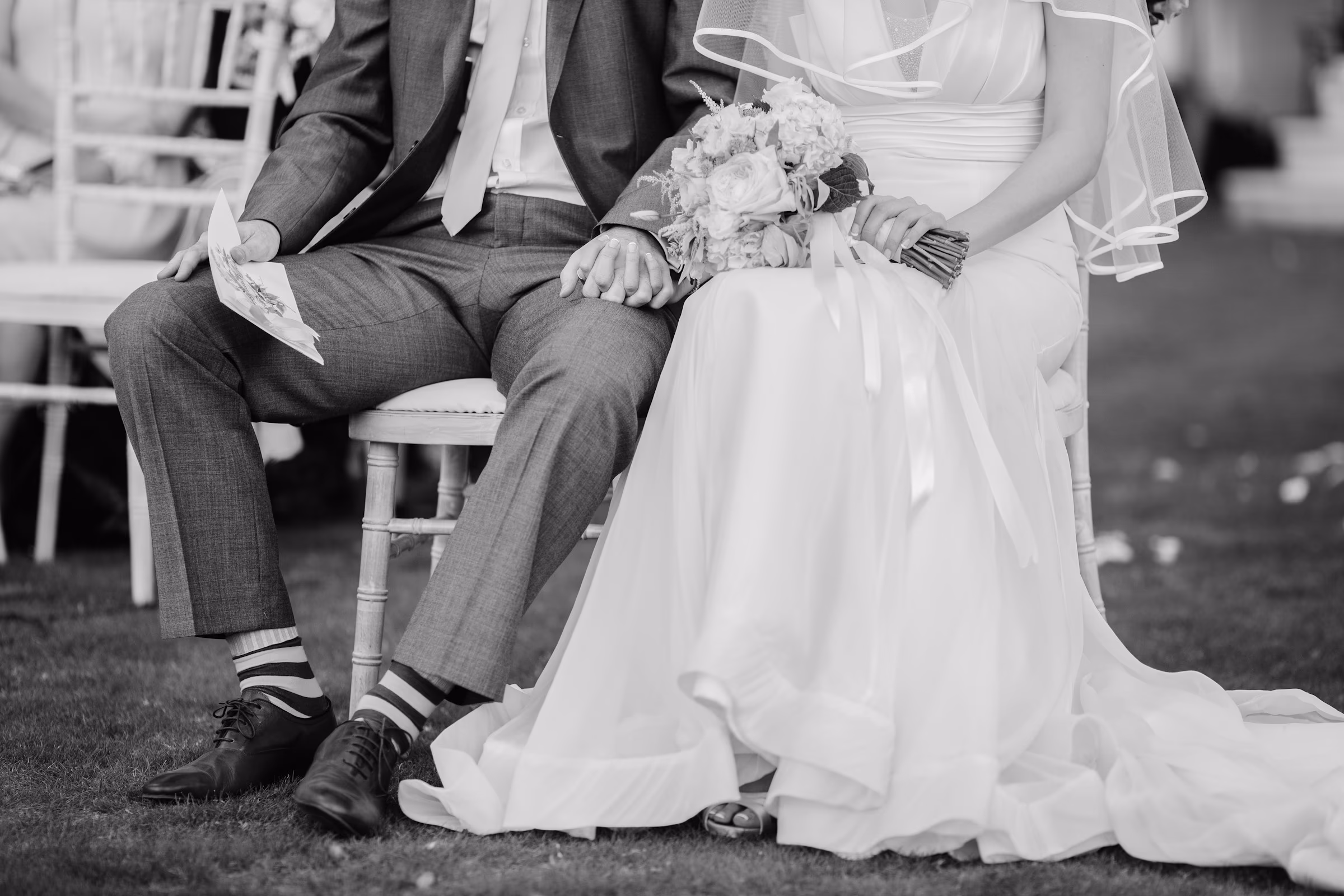 Newlyweds seated together in a quiet black-and-white portrait